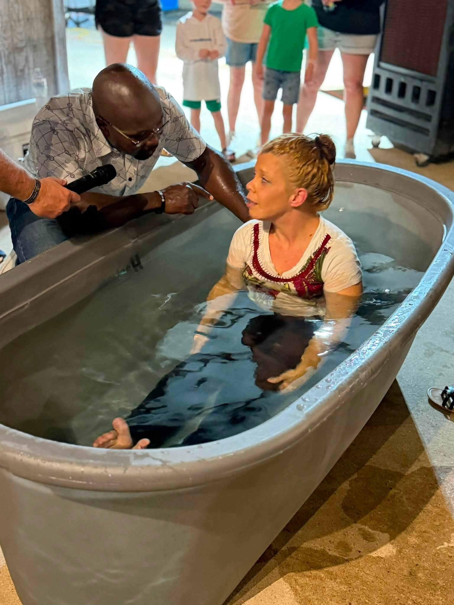 A baptism with ministry volunteers gathered beside the water.