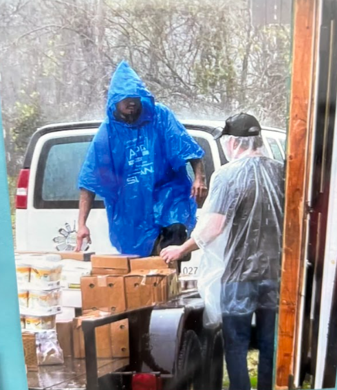 Inner City Ministries volunteers sharing supplies outdoors in the rain